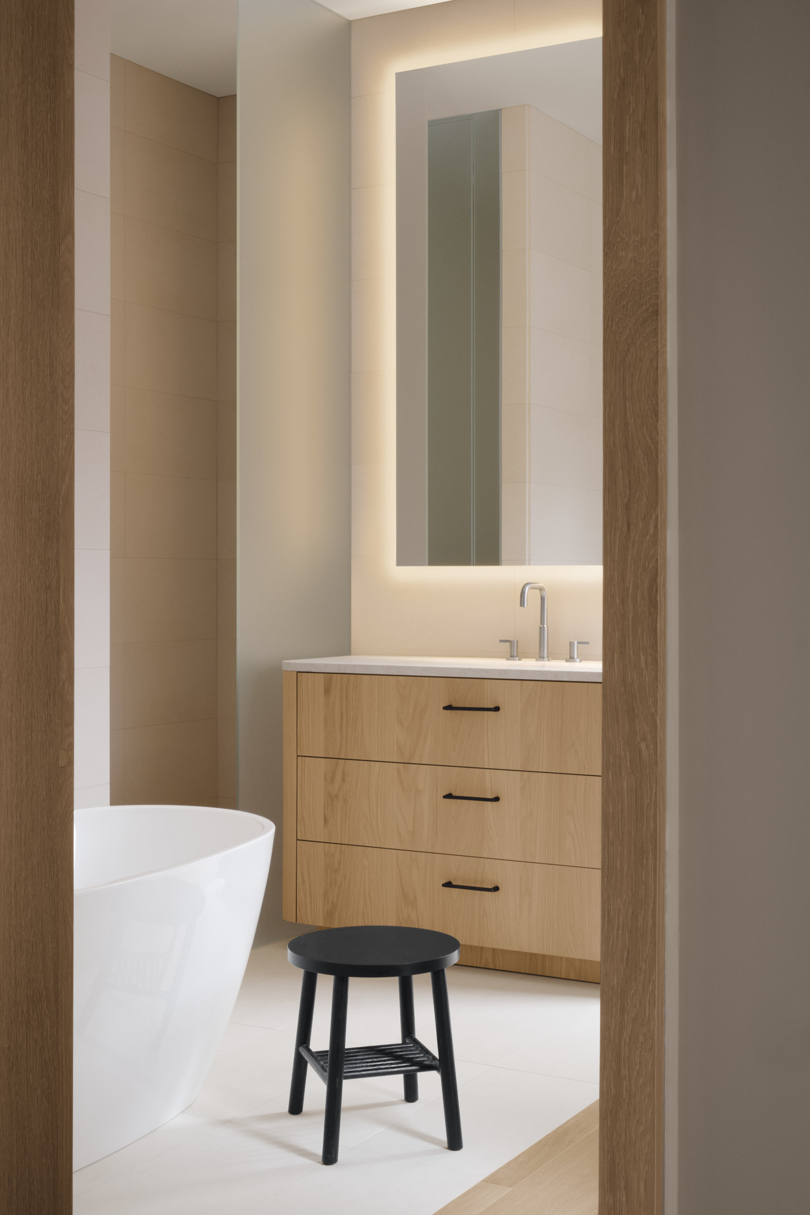 a small tame stool acting as a side table in a bathroom