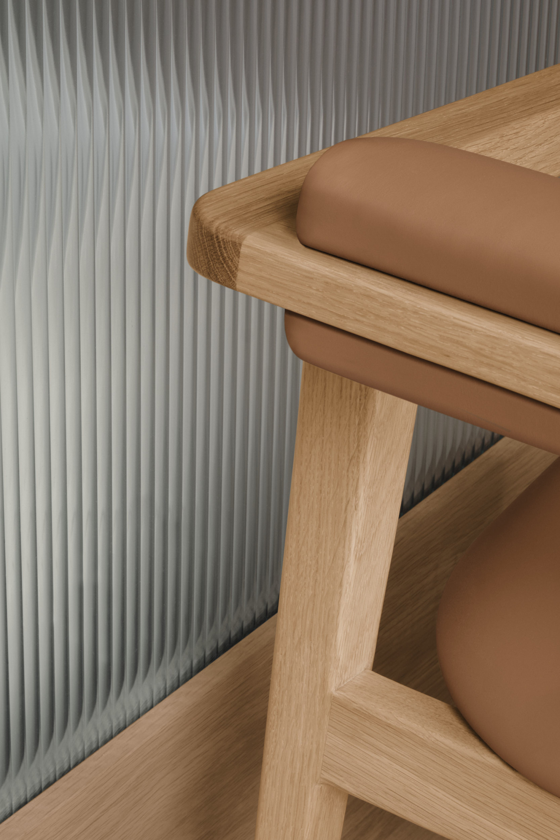 detail of rear of Nord chair backrest revealing it's striking back rail wrapped by upholstered backrest