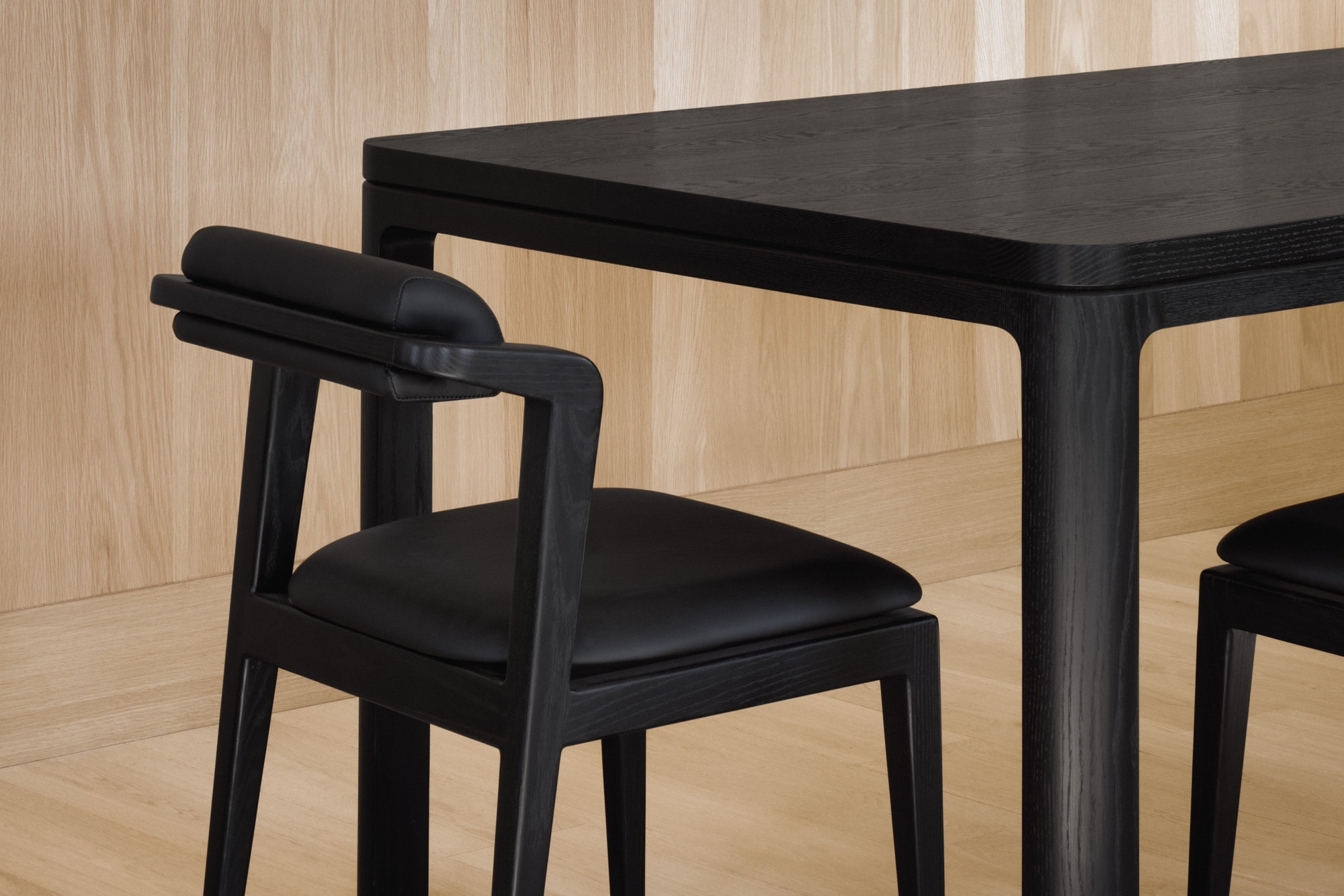 Nord chair without armrests in all black next to black Nord table