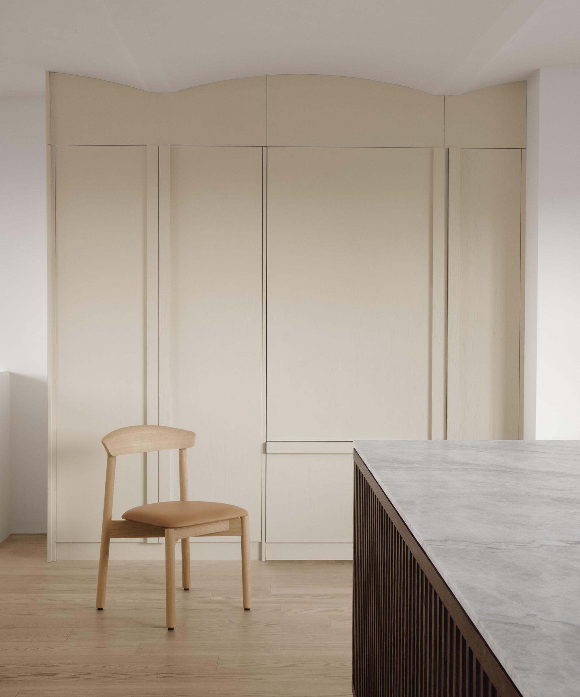 Dune chair in front of arched cream colored cabinet