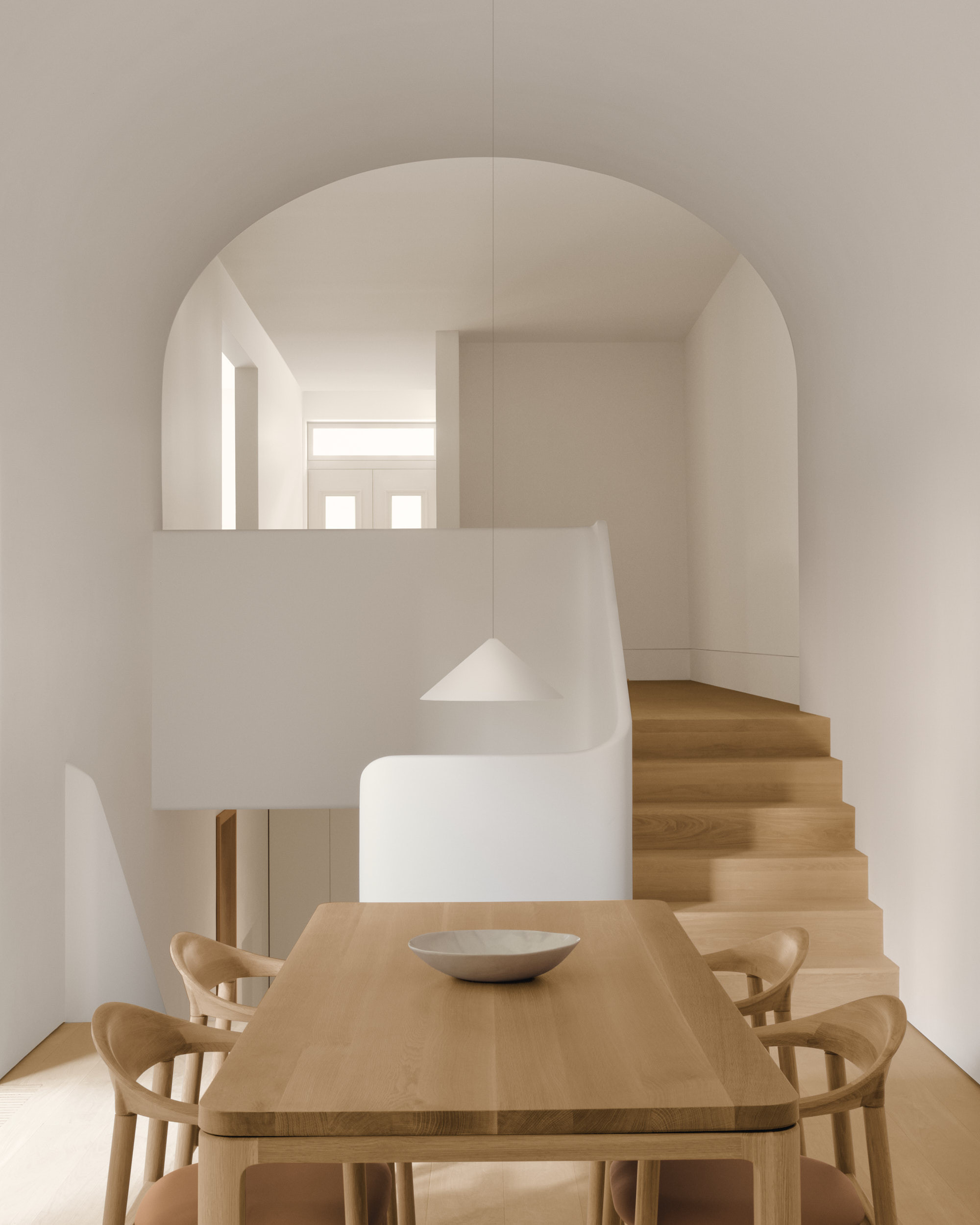 An arch ceiling over a split level area where a Nord table and Dune chair set is placed in the lower section