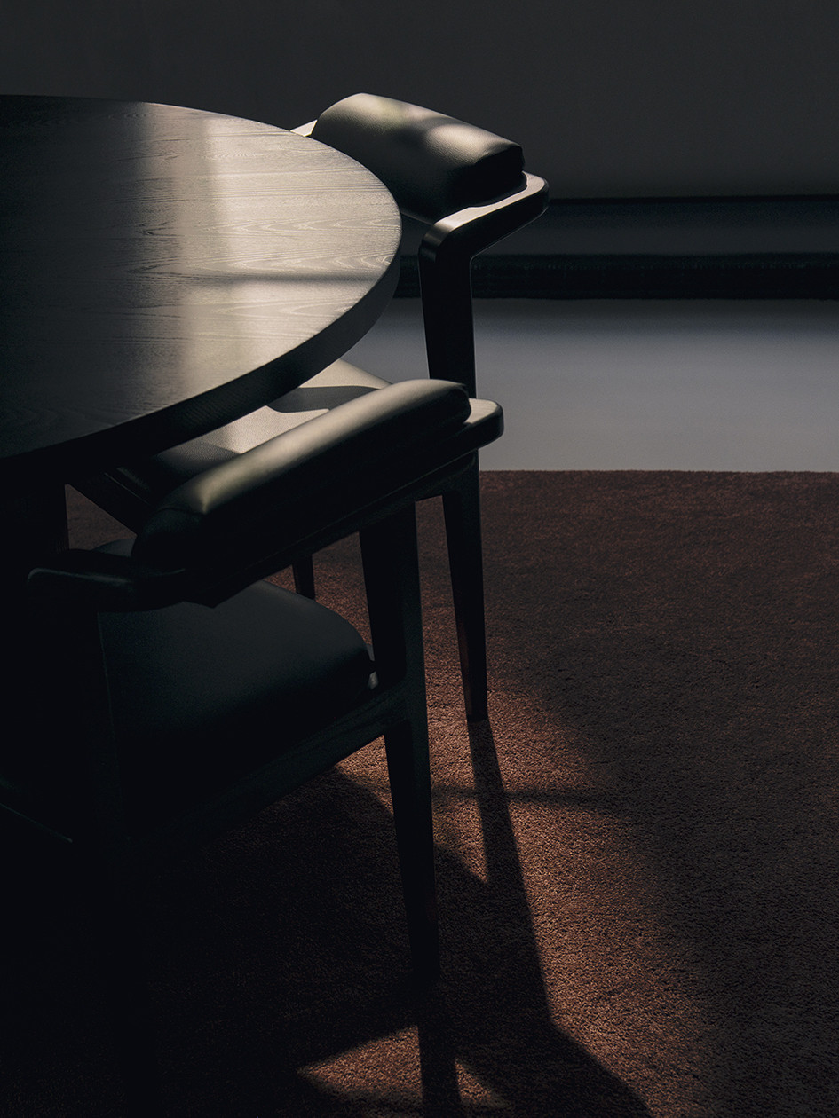 Two Nord chairs around custom round table in a play of light and shadow
