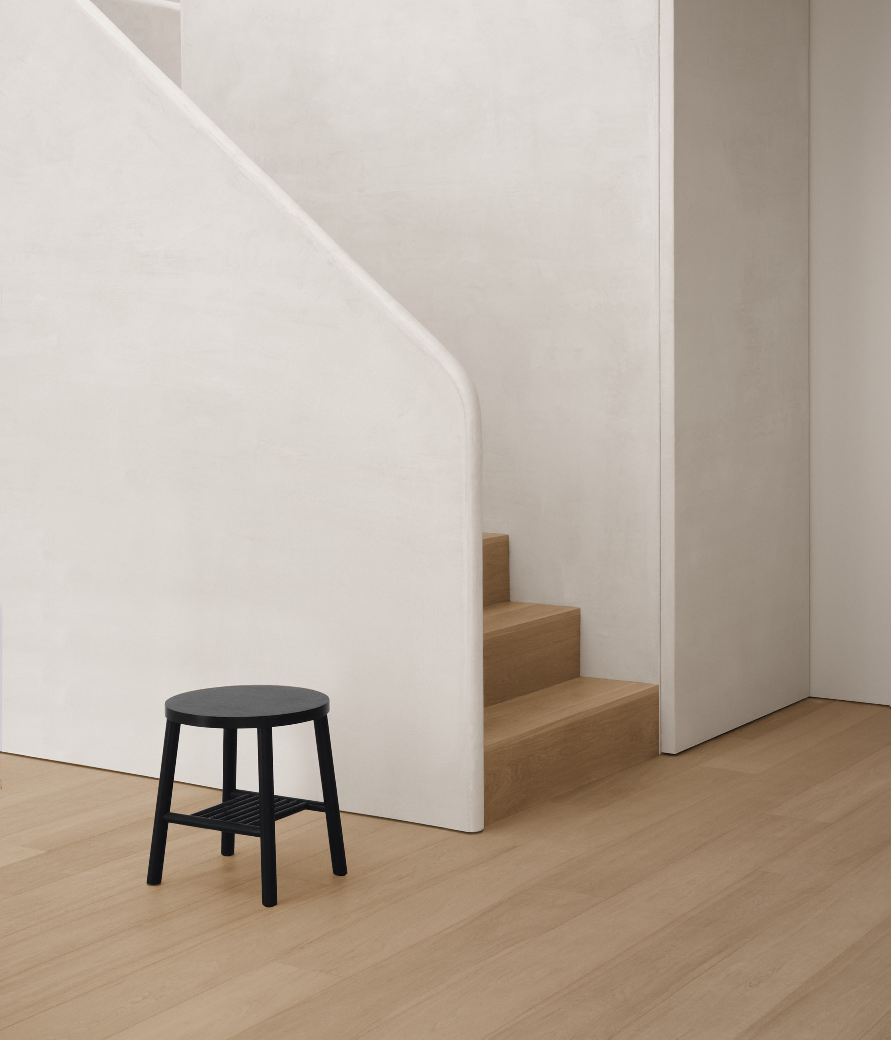 black stool against textured stair case