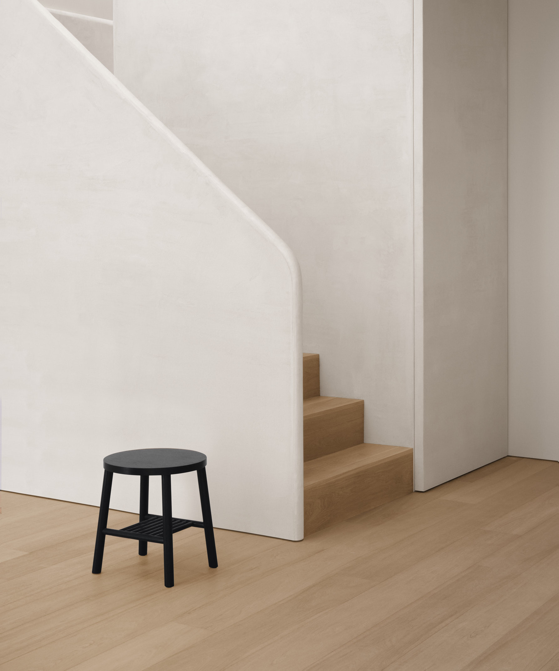 black stool against textured stair case