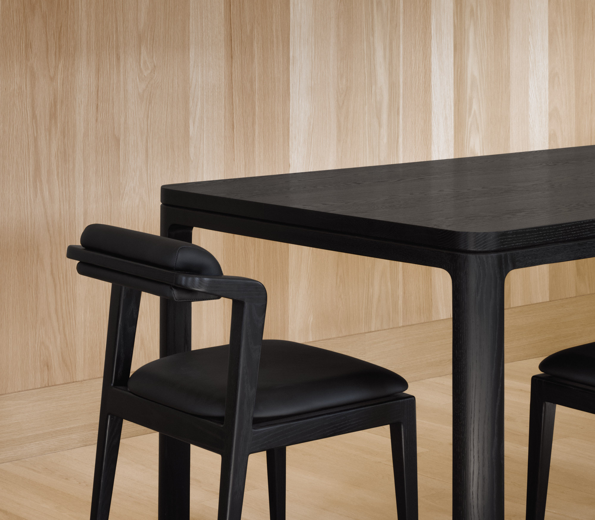 Nord chair without armrests in all black next to black Nord table