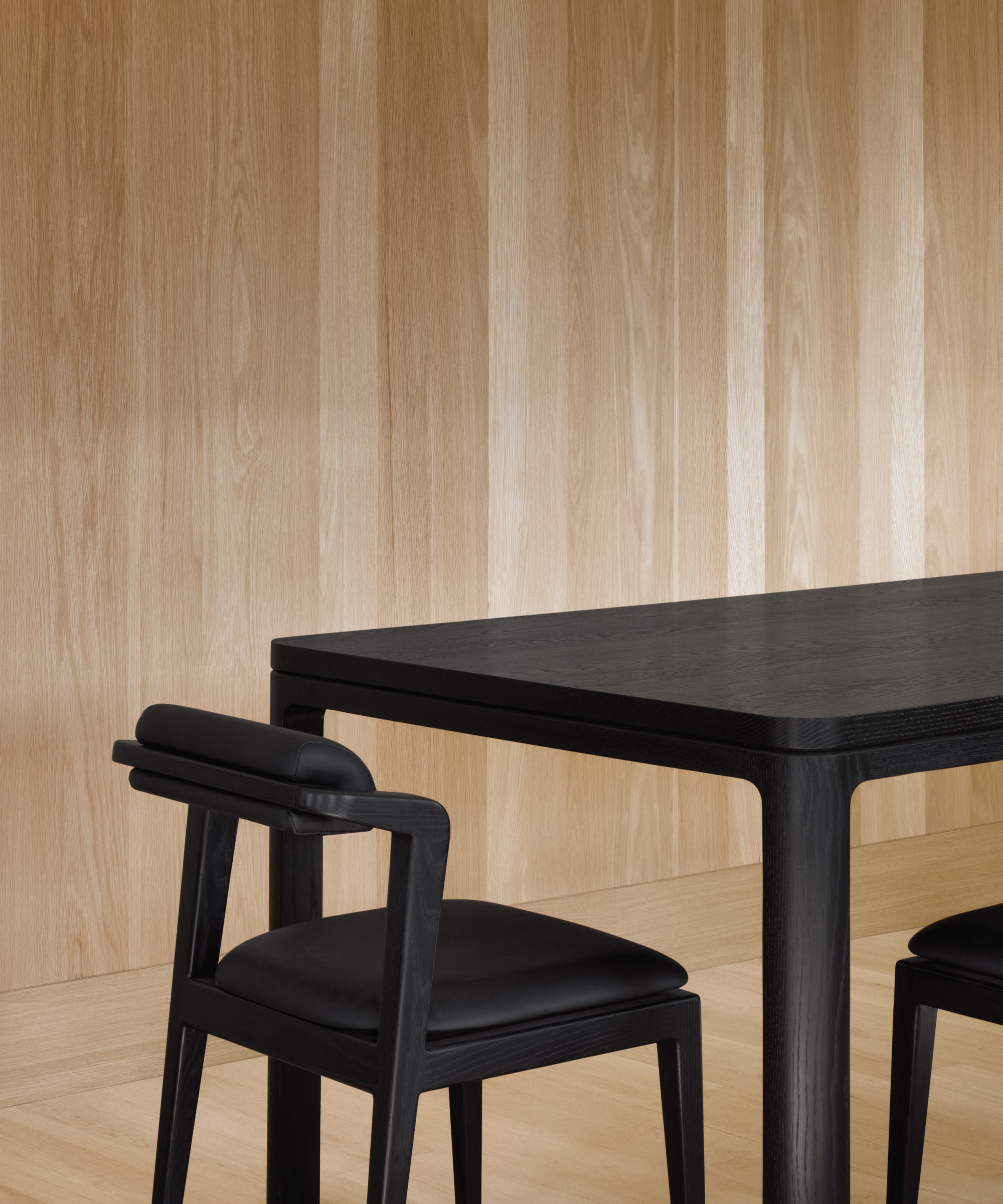 Nord chair without armrests in all black next to black Nord table